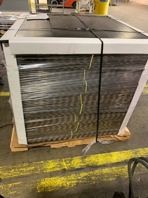 Fully wrapped pallet of wall panels with edge protectors and straps